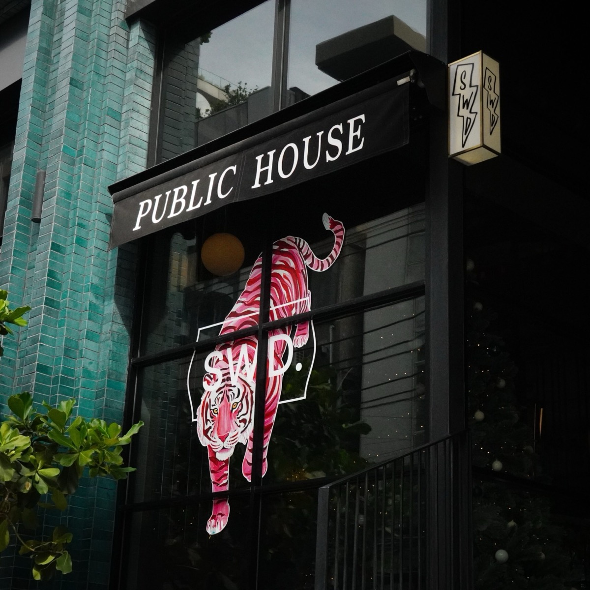 The Public House design hotel facade on Soi 31, with its tiled frontage and tiger artwork